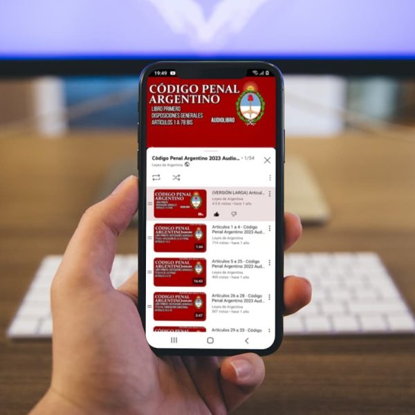 Mano sosteniendo un celular que reproduce el audiolibro del Código Penal Argentino